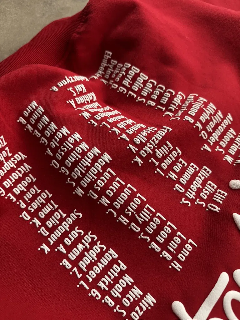 3D-Puffprint mit Namensliste auf dem roten Abihoodie